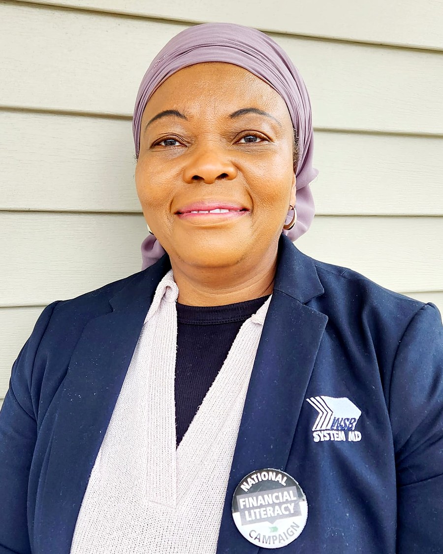 Rashidatu Nyei, licensed financial advisor, smiling outdoors in a navy blazer